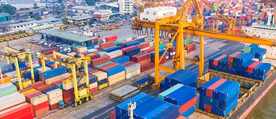 A ship awaits loading of containers at a seaport