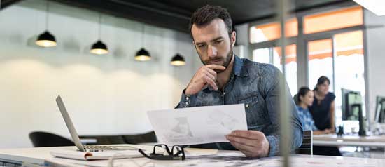 A business man considers a proposal to start a business while seated in an office