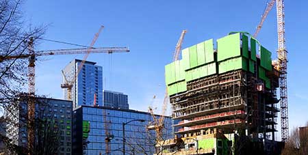 Construction cranes dot the skyline of Seattle, experiencing unparalleled growth.