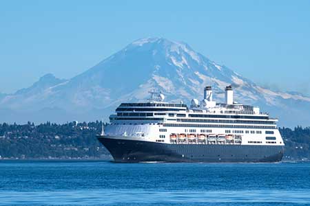 A cruise ship bound for Alaska leaves the Seattle waterfront. Mt. Rainier is in the background.