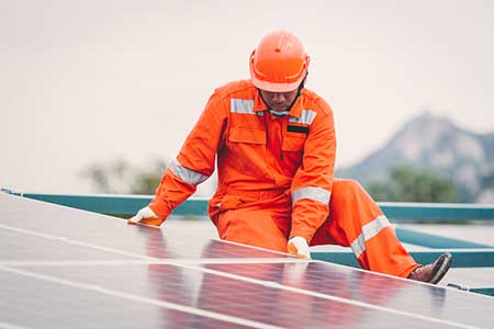 A workman installs solar panels.