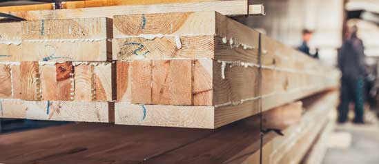 Cross-laminated timber in a mill awaits the glue to dry before being further processed.