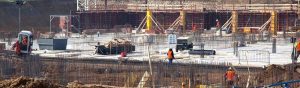 Construction workers finish the foundation of a large skyscraper.